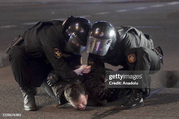 Police officers take a protester into custody as Belarusian opposition supporters take part in a rally against presidential election results, in...