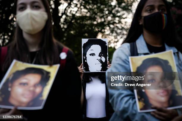 Demonstrators hold up images of Breonna Taylor as they rally in front of the U.S. Department of Justice in protest following a Kentucky grand jury...