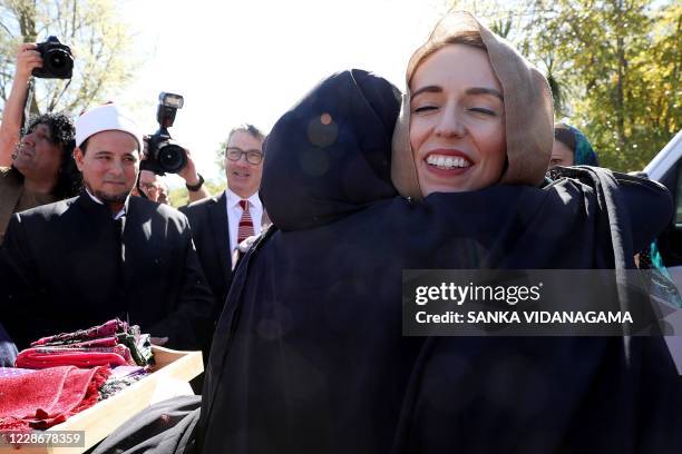 New Zealand's Prime Minister Jacinda Ardern greets members of the Muslim community as she arrives at the mosque to unveil a plaque in memory of the...