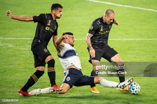 Lucas Cavallini of Vancouver Whitecaps battles Francisco Ginella and Jordan Harvey of Los Angeles FC during Los Angeles FC's MLS match against...
