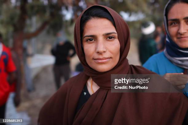 Portrait of a young lady while waiting for food. Women of all ages, from little children girls, adults and elderly are seen in queue asking and...