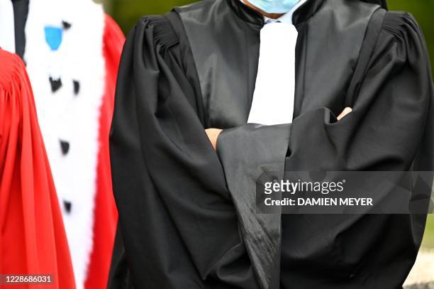 Lawyer wearing a court robe crosses their arms as magistrates gather outside the courthouse of Rennes, western France, on September 24 during a...