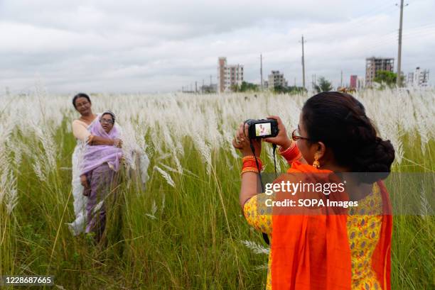 People take photos at a catkins field in Dia Bari. Dia Bari is the most popular attractive destination for tourists in Dhaka. It is a very nice green...