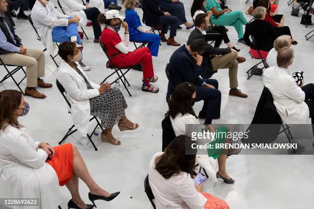 People listen as US President Donald Trump speaks about healthcare at Charlotte Douglas International Airport on September 24 in Charlotte, North...