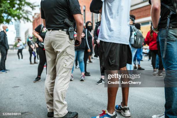 Private security officer and protester speak on the road near the Metro Department of Corrections on September 24, 2020 in Louisville, Kentucky....