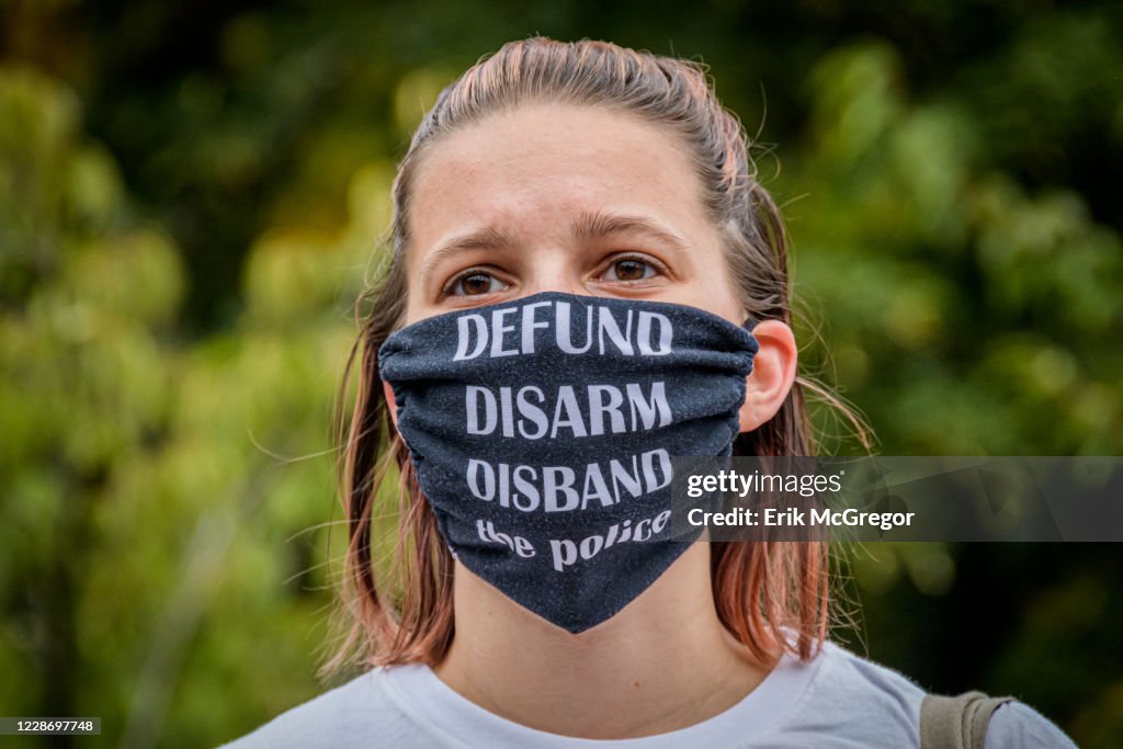 A participant wearing a Defund The Police face mask at the...