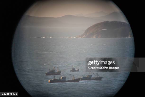 North Korea territory and fishing boats are seen through a pair of viewing binoculars from Yeonpyeong island observatory. North Korea shot and burned...