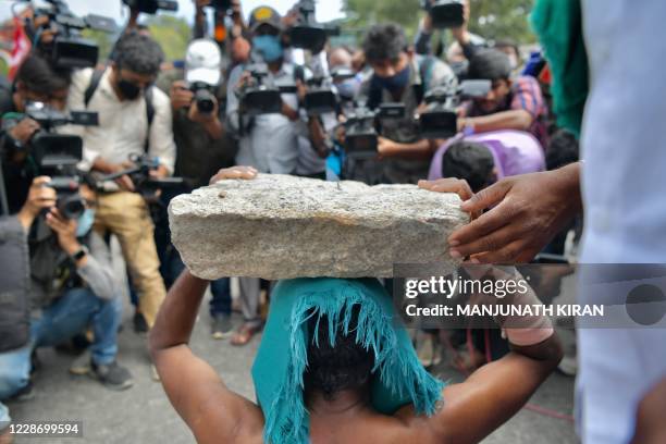 Media personnel document an activist from a farmer right organisation during a protest following the recent passing of agriculture bills in the Lok...