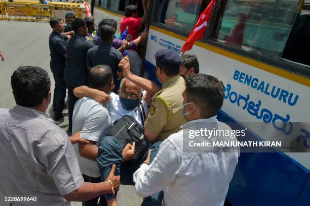 Police personnel detain an activist from a farmers rights organisation during a protest following the recent passing of agriculture bills in the Lok...