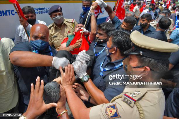 Police personnel detain an activist from a farmers rights organisation during a protest following the recent passing of agriculture bills in the Lok...