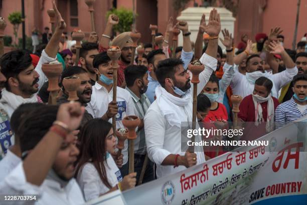 Activists of the National Students' Union of India shout slogans as they hold torches during a nationwide farmers' strike following the recent...