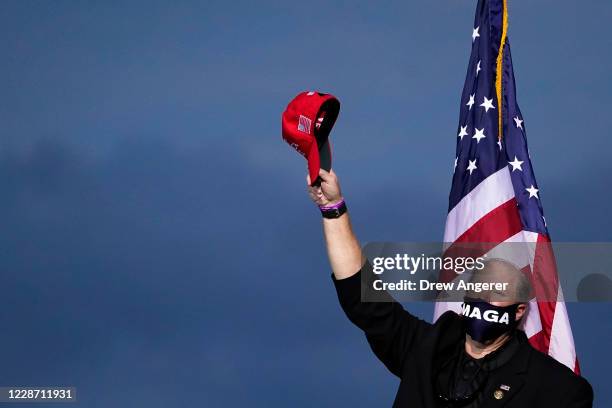 Man cheers after a prayer before the arrival of President Donald Trump during a campaign rally at Newport News/Williamsburg International Airport on...