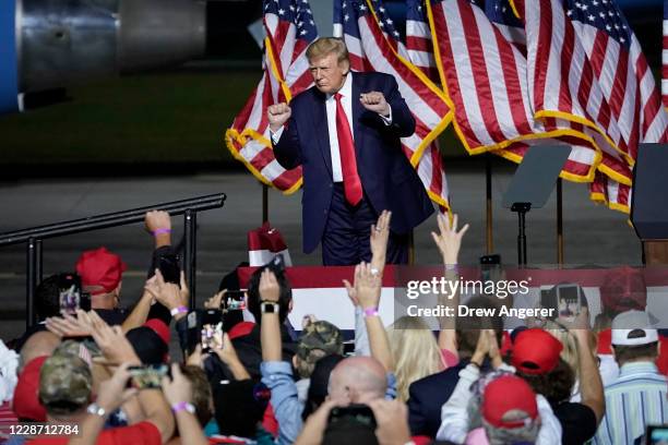 President Donald Trump dances to the song "YMCA" at the end of a campaign rally at Newport News/Williamsburg International Airport on September 25,...