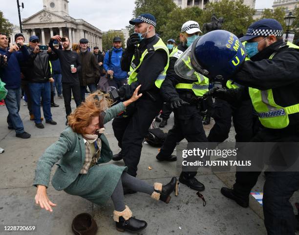 Woman falls as police move in to disperse protesters in Trafalgar Square in London on September 26 at a 'We Do Not Consent!' mass rally against...