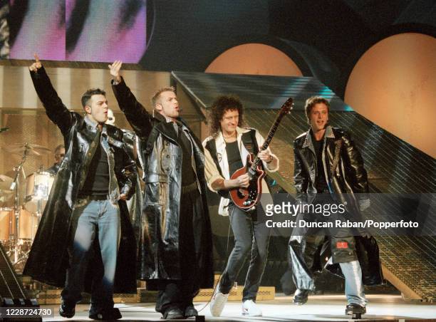 Brian May of Queen performing with Scott Robinson, Jason Brown and Ritchie Neville of the band Five during the Brit Awards at Earls Court Exhibition...