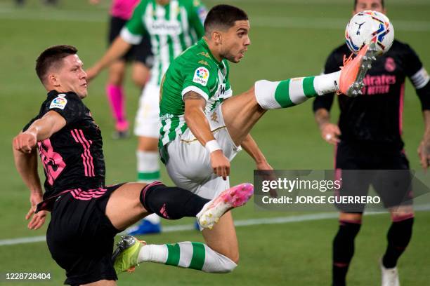 Real Madrid's Serbian forward Luka Jovic vies with Real Betis' Spanish defender Marc Bartra during the Spanish league football match Real Betis...