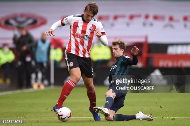 Leeds United's English striker Patrick Bamford tackles Sheffield United's Norwegian midfielder Sander Berge during the English Premier League...