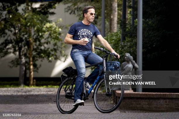 Dutch Prime Minister Mark Rutte arrives on a bike at the Catshuis for an informal meeting about Covid-19, in The Hague, on September 27, 2020. /...