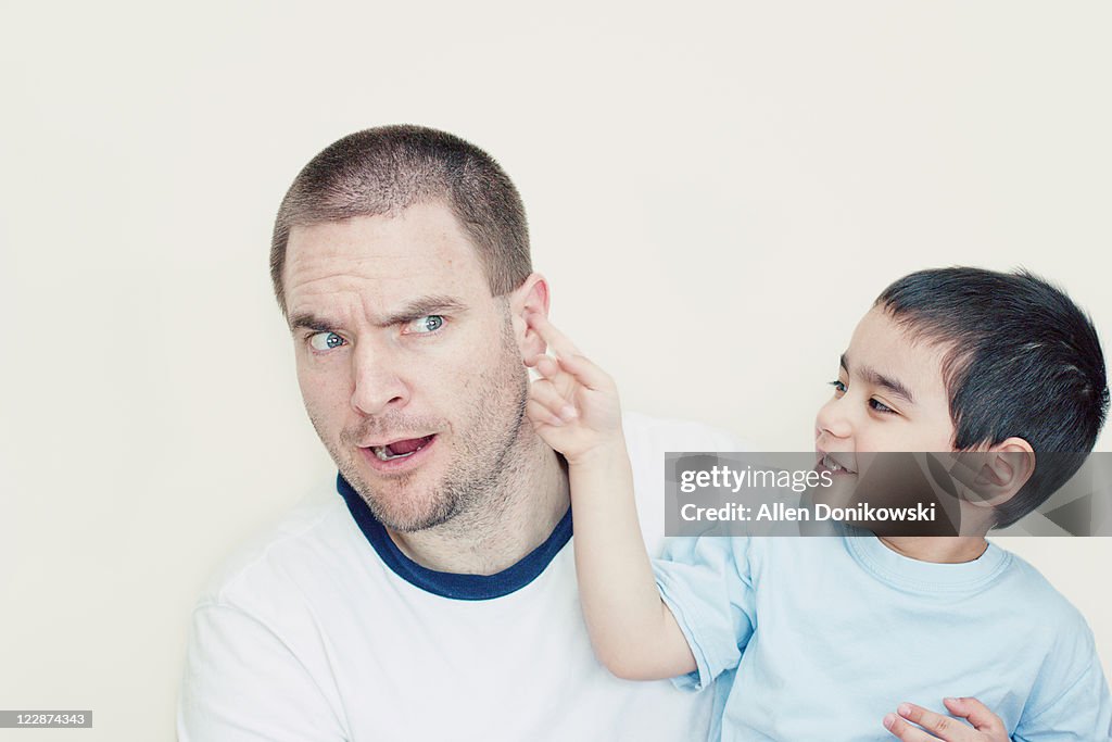 Boy pokes his dad in ear