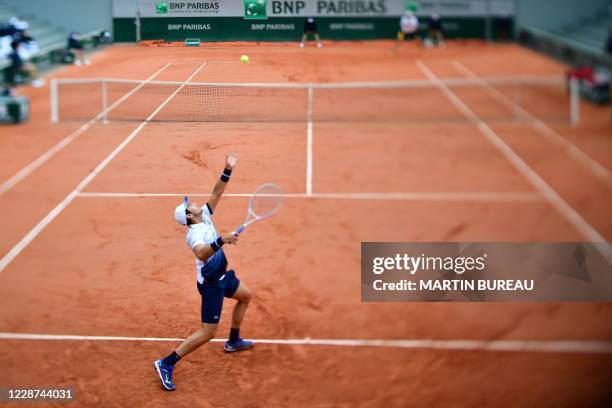 France's Elliot Benchetrit serves the ball to John Isner of the US during their men's singles first round tennis match on Day 1 of The Roland Garros...