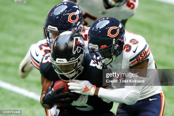 Russell Gage of the Atlanta Falcons is hit hard by Buster Skrine and Eddie Jackson of the Chicago Bears during the second quarter of an NFL game at...