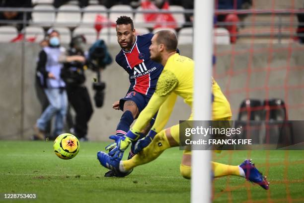 Paris Saint-Germain's Brazilian forward Neymar kicks the ball and misses a goal opportunity as Reims' Serbian goalkeeper Predrag Rajkovic dives to...