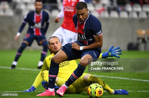 Paris Saint-Germain's French forward Kylian Mbappe moves with the ball past Reims' Serbian goalkeeper Predrag Rajkovic during the French L1 football...