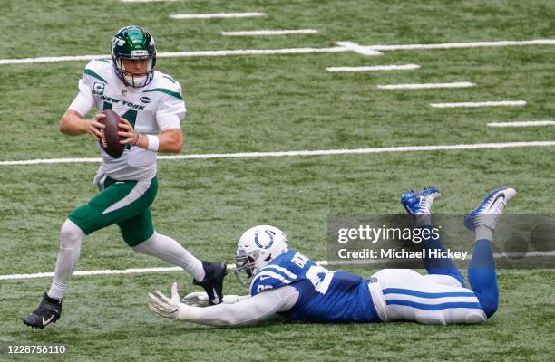 Sam Darnold of the New York Jets escapes the tackle from DeForest Buckner of the Indianapolis Colts during the first half at Lucas Oil Stadium on...