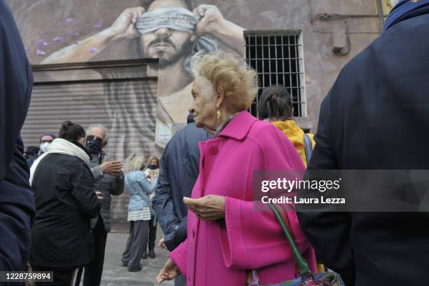 People gather in front of the mural 'Fiori di Glicine' by Italian street artist Ligama on September 27, 2020 in Livorno, Italy. The mural celebrates...