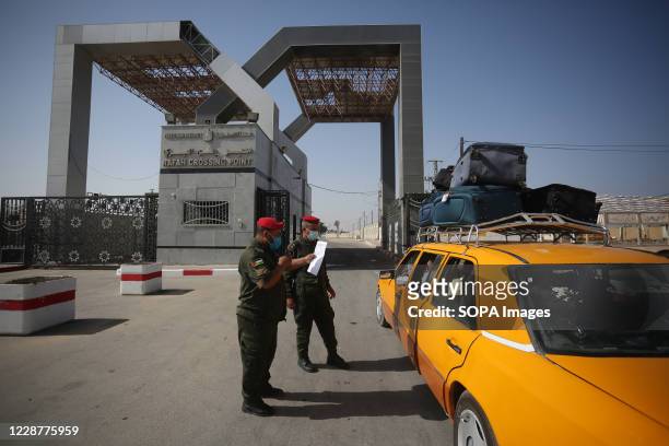 Members of Palestinian security forces speak with passengers sitting in car as they wait to leave the Rafah border crossing with Egypt. Egypt...
