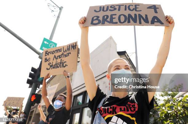 Demonstrators including Ell M. Of La Cañada, right, and Justin Warren of Simi Valley, at left, hold signs at the intersection of Foothill Boulevard...