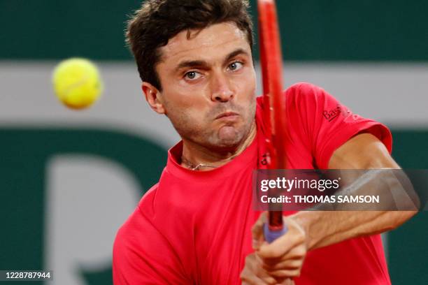 France's Gilles Simon returns the ball to Canada's Denis Shapovalov during their men's singles first round tennis match at the Philippe Chatrier...