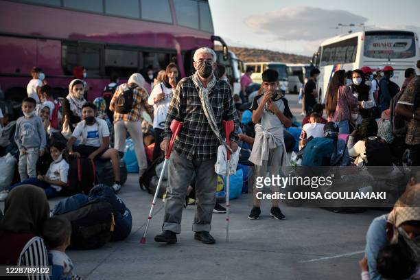 Refugees from the islands of Lesbos, Chios, Samos, Kos and Leros wait to board buses after disembarking at the port of Lavrio, some 70 km south-east...