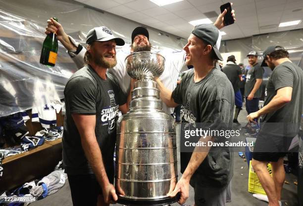 Steven Stamkos, Nikita Kucherov and Ondrej Palat of the Tampa Bay Lightning celebrate with the Stanley Cup in the locker room after the Tampa Bay...