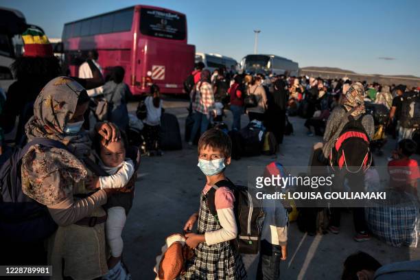 Refugees from the islands of Lesbos, Chios, Samos , Kos and Leros wait to board buses after disembarking at the port of Lavrio, some 70 km south-east...