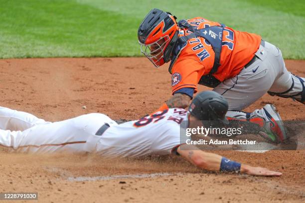 Martin Maldonado of the Houston Astros unsuccessfully attempts the tag on Max Kepler of the Minnesota Twins allowing the first run of the game in the...