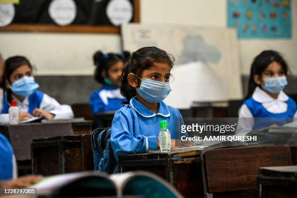 Children wearing facemasks attend a class at a school in Islamabad on September 30 after the educational institutes reopened primary classes in the...
