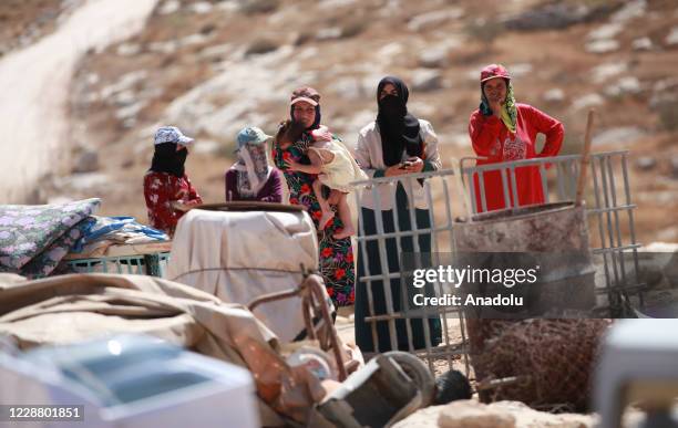 Palestinian women look on as Israeli excavators demolish some of constructions belonging to Palestinians for allegedly being unauthorized and being...