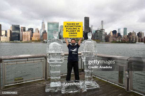 Activist Katie Flynn hold banners as Greenpeace placed life-size ice sculptures of U.S President Donald Trump and Brazilian President Bolsonaro to...