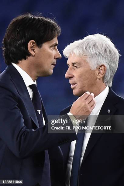 Lazio's Italian coach Simone Inzaghi and Atalanta's Italian coach Gian Piero Gasperini pass each other on the pitch at the end of the Italian Serie A...