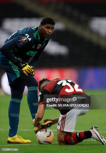 Brazil's Flamengo defender Gabriel Noga ties the boot laces of Brazil's Flamengo goalkeeper Hugo Souza during their closed-door Copa Libertadores...