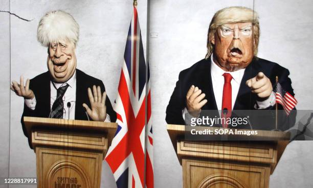 Prime Minister Boris Johnson and US President Donald Trump are pictured in this panel. Caricatures of politicians on large advertisement board for...