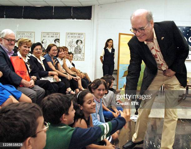 El dibujante de historietas argentino Salvador Lavado, conocido como Quino, saluda a unos niños al empezar un charla en Guayaquil, Ecuador, el 21 de...