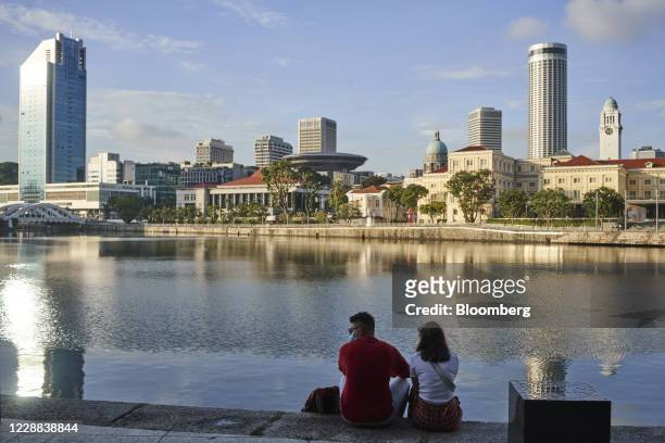 People sit on the river bank in Singapore, on Thursday, Oct. 1, 2020. Singapore's total population has fallen for the first time in 17 years as the...