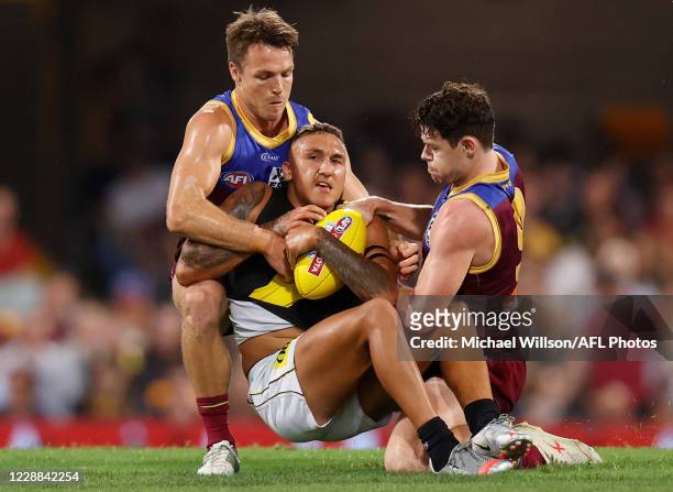 Shai Bolton of the Tigers is tackled by Lincoln McCarthy of the Lions and Lachie Neale of the Lions during the 2020 AFL Second Qualifying Final match...