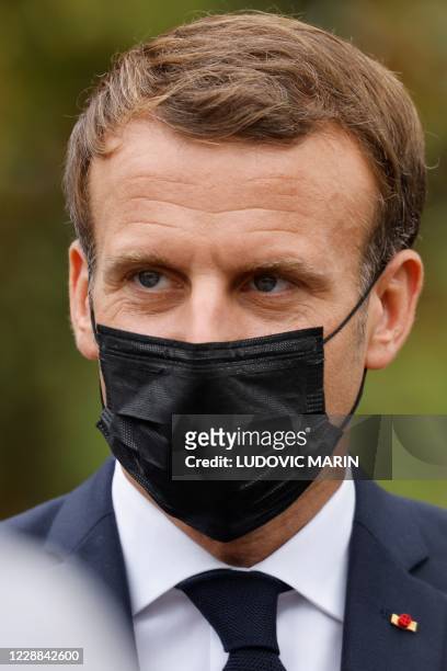 French President Emmanuel Macron wearing a protective face mask speaks arrives at 'la Maison des habitants' to meet and have lunch with young...