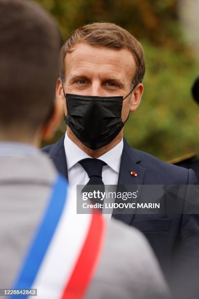 French President Emmanuel Macron wearing a protective face mask speaks arrives at 'la Maison des habitants' to meet and have lunch with young...