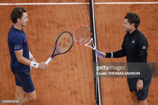 Winner Austria's Dominic Thiem congratulates Norway's Casper Ruud as they touch their rackets at the end of their men's singles third round tennis...