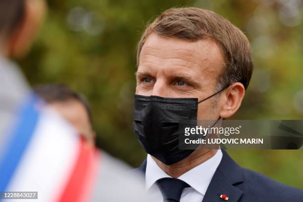 French President Emmanuel Macron wearing a protective face mask speaks arrives at 'la Maison des habitants' to meet and have lunch with young...