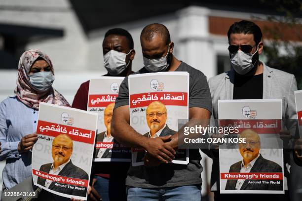 Friends of murdered Saudi journalist Jamal Khashoggi hold posters bearing his picture as they attend an event marking the second-year anniversary of...